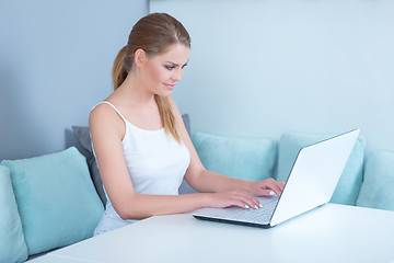 Image showing Attractive young woman using a laptop at home