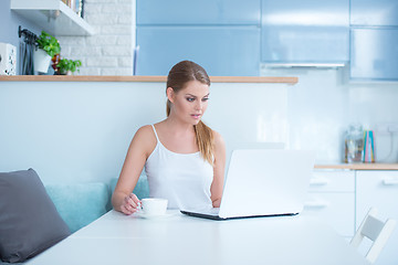 Image showing Woman Sitting at Table with Laptop and Mug