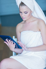 Image showing Woman in Bath Towel Looking at Tablet Computer