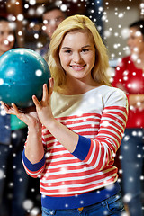 Image showing happy young woman holding ball in bowling club