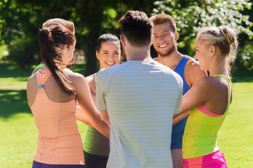 Image showing group of happy friends with hands on top outdoors