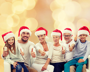 Image showing happy family in santa hats showing thumbs up