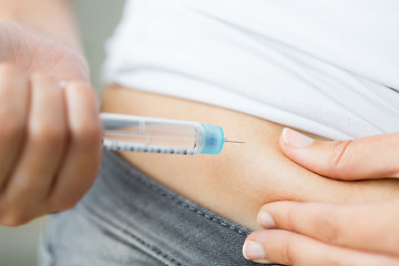 Image showing close up of hands making injection by insulin pen