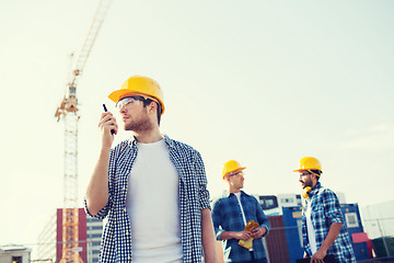 Image showing group of builders in hardhats with radio