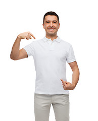 Image showing smiling man in t-shirt pointing fingers on himself