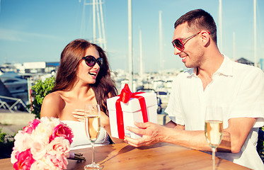 Image showing smiling couple with gift box cafe