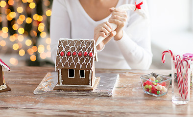 Image showing close up of woman making gingerbread house at home