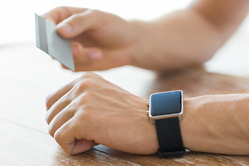 Image showing close up of hands with smart watch and credit card