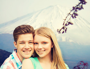 Image showing smiling couple hugging over mountains background