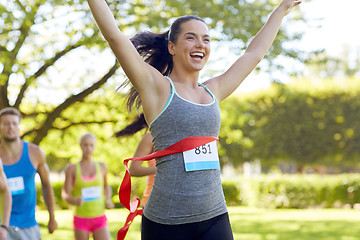 Image showing happy young female runner winning on race finish