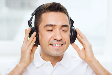 Image showing happy man in headphones listening to music at home