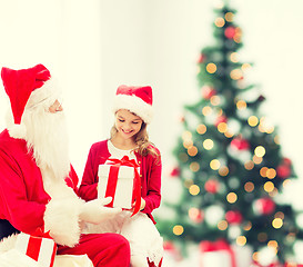 Image showing smiling little girl with santa claus and gifts