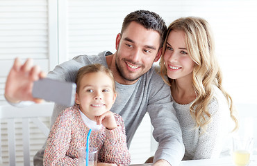 Image showing happy family taking selfie at restaurant