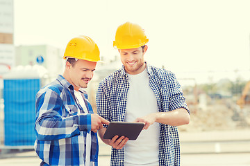 Image showing smiling builders in hardhats with tablet pc