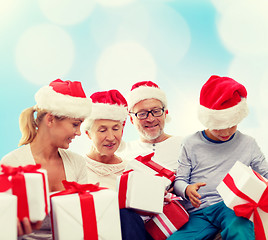 Image showing happy family in santa helper hats with gift boxes