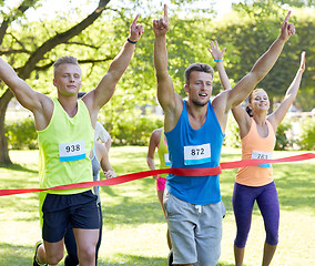 Image showing happy young male runner winning on race finish