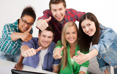 Image showing group of happy students showing thumbs up