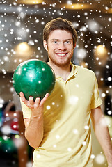 Image showing happy young man holding ball in bowling club