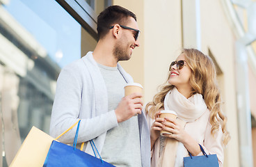 Image showing happy couple with shopping bags and coffee in city