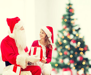 Image showing smiling little girl with santa claus and gifts