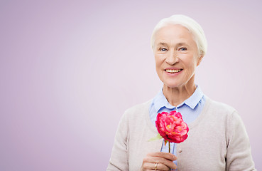 Image showing happy smiling senior woman with flower