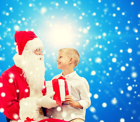 Image showing smiling little boy with santa claus and gifts