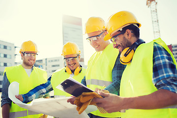 Image showing group of builders with tablet pc and blueprint