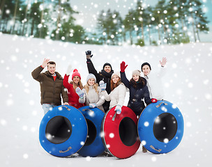 Image showing group of smiling friends with snow tubes