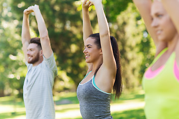 Image showing group of friends or sportsmen exercising outdoors