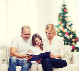 Image showing happy family with book at home