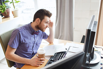 Image showing creative male worker with computer drinking coffee