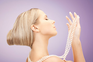 Image showing beautiful woman with pearl necklace over violet