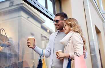 Image showing happy couple with shopping bags and coffee in city