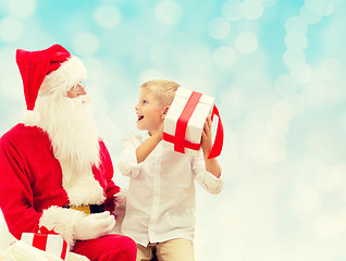 Image showing smiling little boy with santa claus and gifts