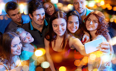 Image showing friends with smartphone taking selfie in club