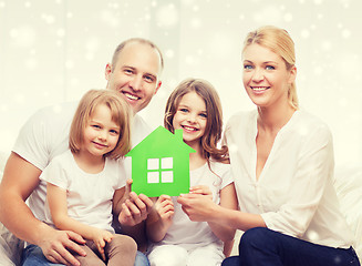 Image showing happy family with two kids and paper house at home