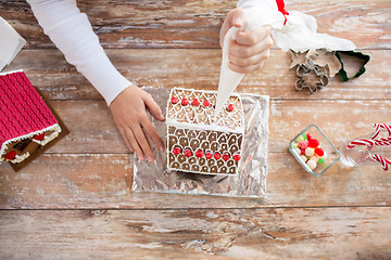 Image showing close up of woman making gingerbread houses