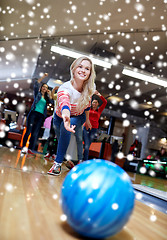 Image showing happy young woman throwing ball in bowling club