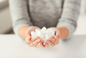 Image showing close up of white lump sugar in woman hands