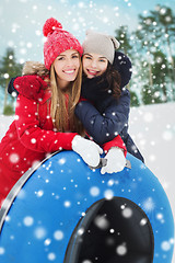 Image showing happy girl friends with snow tubes outdoors