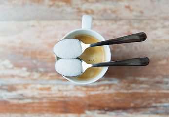 Image showing close up of white sugar on teaspoon and coffee cup