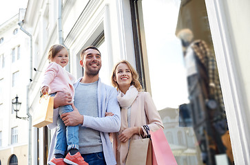 Image showing happy family with child and shopping bags in city