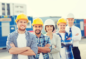 Image showing group of smiling builders in hardhats outdoors