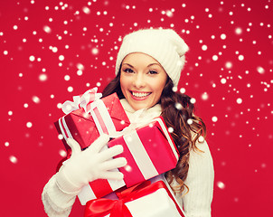 Image showing woman in sweater and hat with many gift boxes