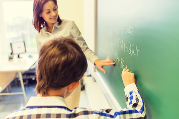 Image showing school boy with teacher writing on chalk board