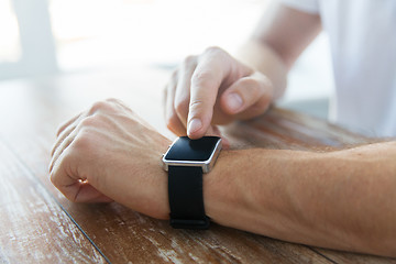 Image showing close up of male hands setting smart watch