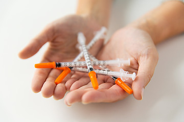 Image showing close up of woman hands holding insulin syringes