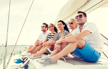 Image showing smiling friends sitting on yacht deck