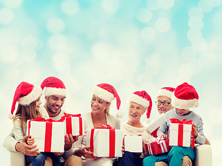 Image showing happy family in santa helper hats with gift boxes