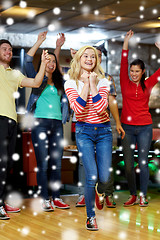 Image showing happy young woman throwing ball in bowling club